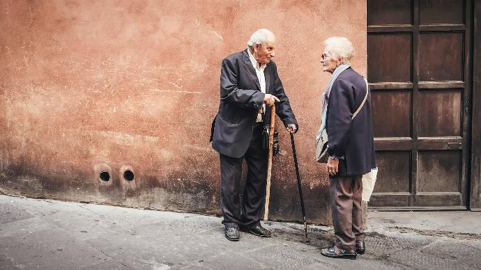 two person talking while standing near wall