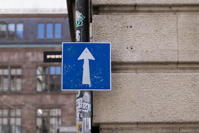 a blue and white sign on a pole next to a building